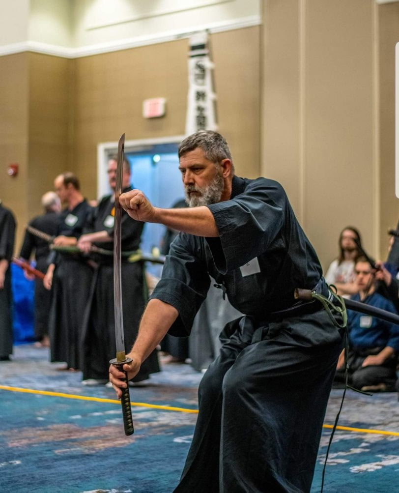 Sigung Joe Bostick with a Sword on the Contact Page